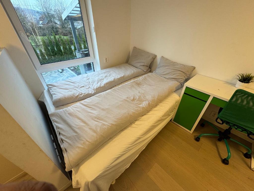 Cama en habitación con escritorio y ventana en Lillestrøm home hybel uten soverom, en Lillestrøm