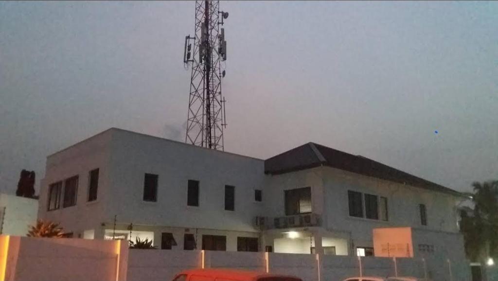 a white building with a tower on top of it at Helios Towers in Accra