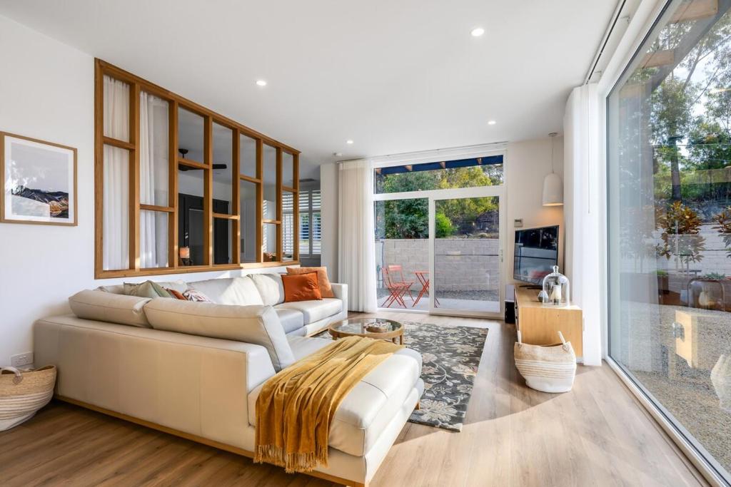 a living room with a white couch and windows at Magnolia - Your Private Luxury Escape Awaits in Scamander