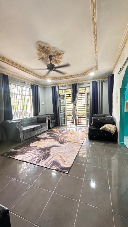 a living room with a ceiling fan and a rug at D’sireh homestay in Sik