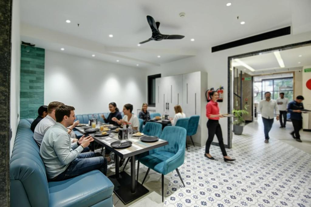a group of people sitting at a table in a restaurant at HOTEL UPTOWN - Luxury Restaurant & Rooftop Near Connaught Place in New Delhi