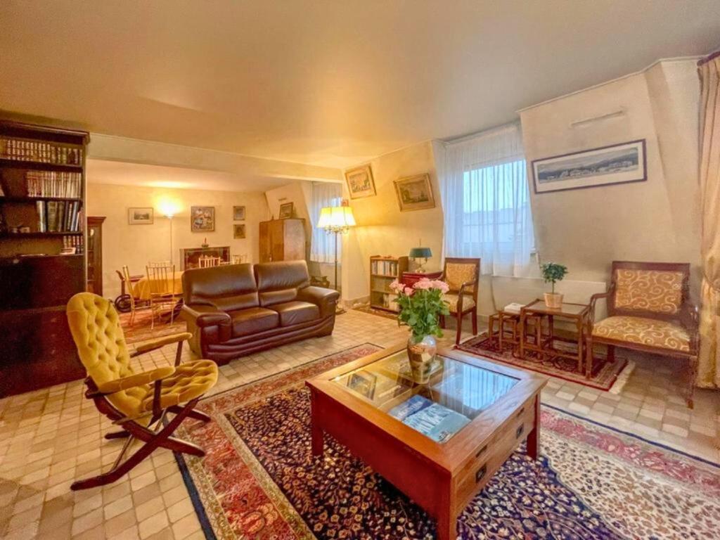 a living room with a couch and a coffee table at La Clé de Marc in Le Vésinet