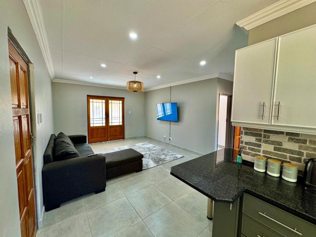 a living room with a couch and a table at Urban Bliss Villa in Klerksdorp