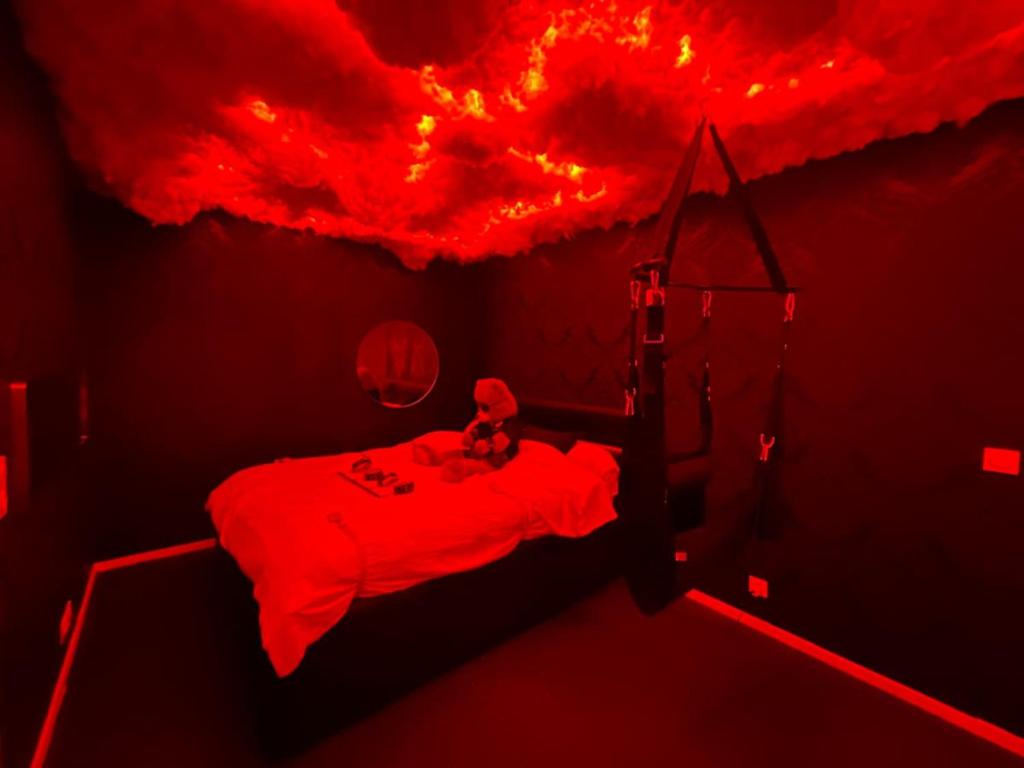 ein rotes Zimmer mit einem Bett und einer Feuerdecke in der Unterkunft Love room - La Parenthèse Douceur in Noisy-le-Grand
