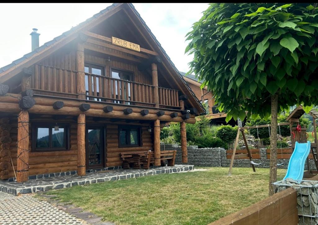 a large wooden house with a balcony on top at Zrub EMMA in Mýto pod Ďumbierom