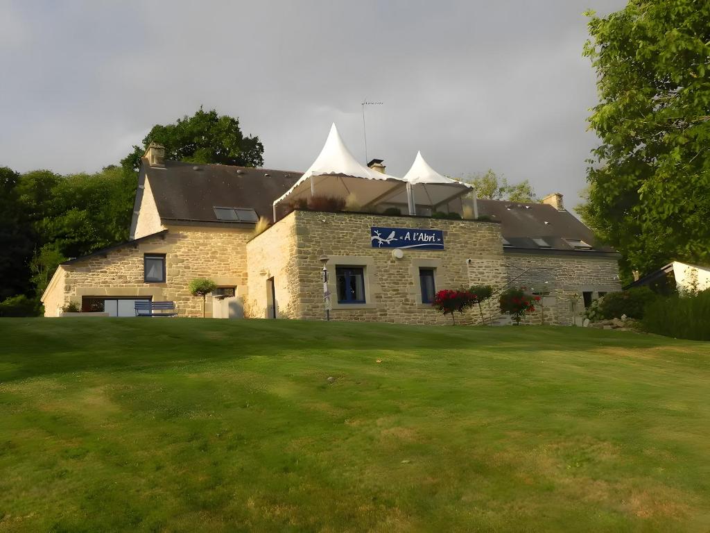 a large stone building with a sign on it at A L'abri in Saint-Nolff