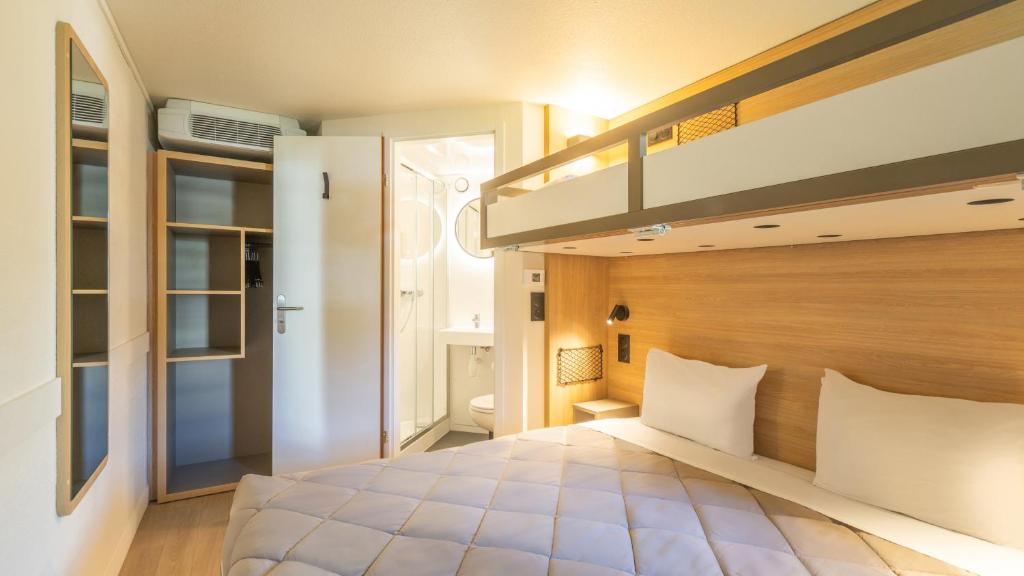 a bedroom with a loft bed and a staircase at Premiere Classe Versailles - Saint Cyr L'ecole in Saint-Cyr-lʼÉcole
