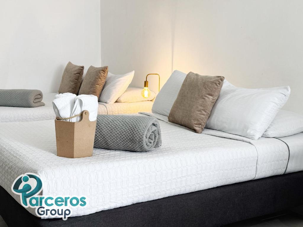 eine weiße Couch mit Kissen und einer Tasche darauf in der Unterkunft Apartamentos Zona Circunvalar Por Parceros Group in Pereira