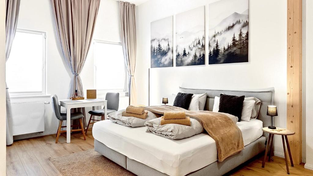 a bedroom with a large white bed and a desk at Stilvolles City-Apartment - Pfalzliebe Suites in Landau in der Pfalz