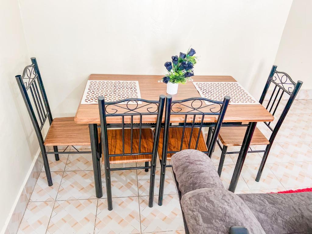 a dining room table and chairs with a vase of flowers on it at Naka homes in Lanet