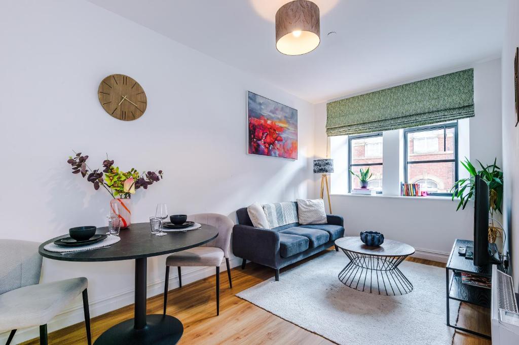 een woonkamer met een bank en een tafel bij Modern Leeds Central Stay -2 min walk from station in Leeds