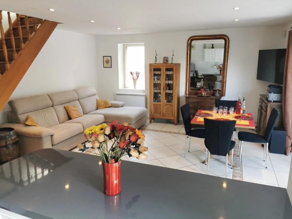 a living room with a couch and a table with flowers at Maison confortable avec jardin à Marseille in Marseille