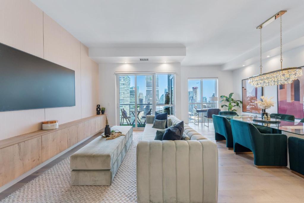 ein Wohnzimmer mit einem Sofa, Stühlen und einer Bar in der Unterkunft Rosewood Skyline Penthouse - CN Tower Views, Downtown Toronto in Toronto