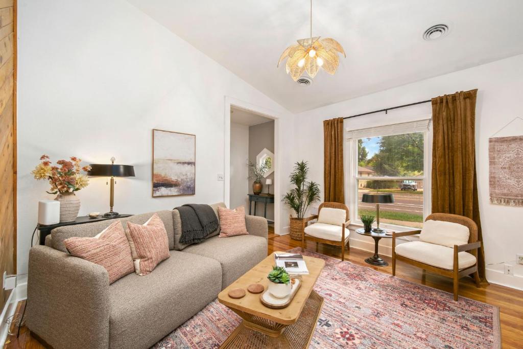 a living room with a couch and a table at Oak Street Bungalow Walk to Old Town and CSU in Buckingham