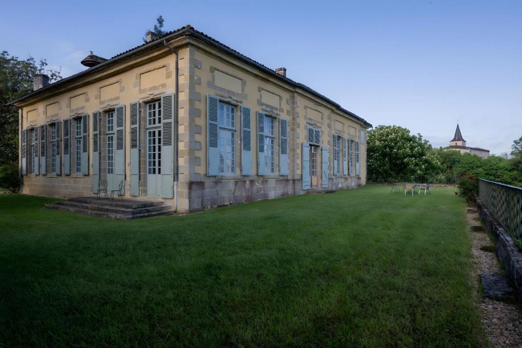 an old building with a grass yard in front of it at Château Puybarban in Puybarban