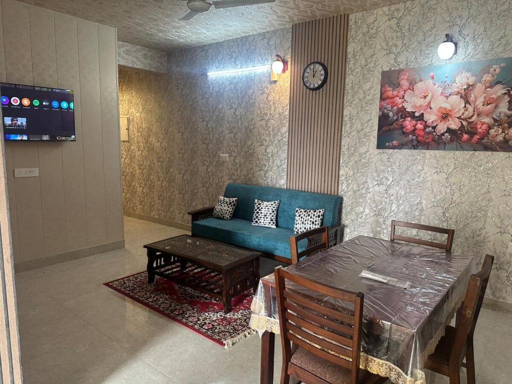 a living room with a table and a blue couch at Taj Nidhi Luxury in Agra