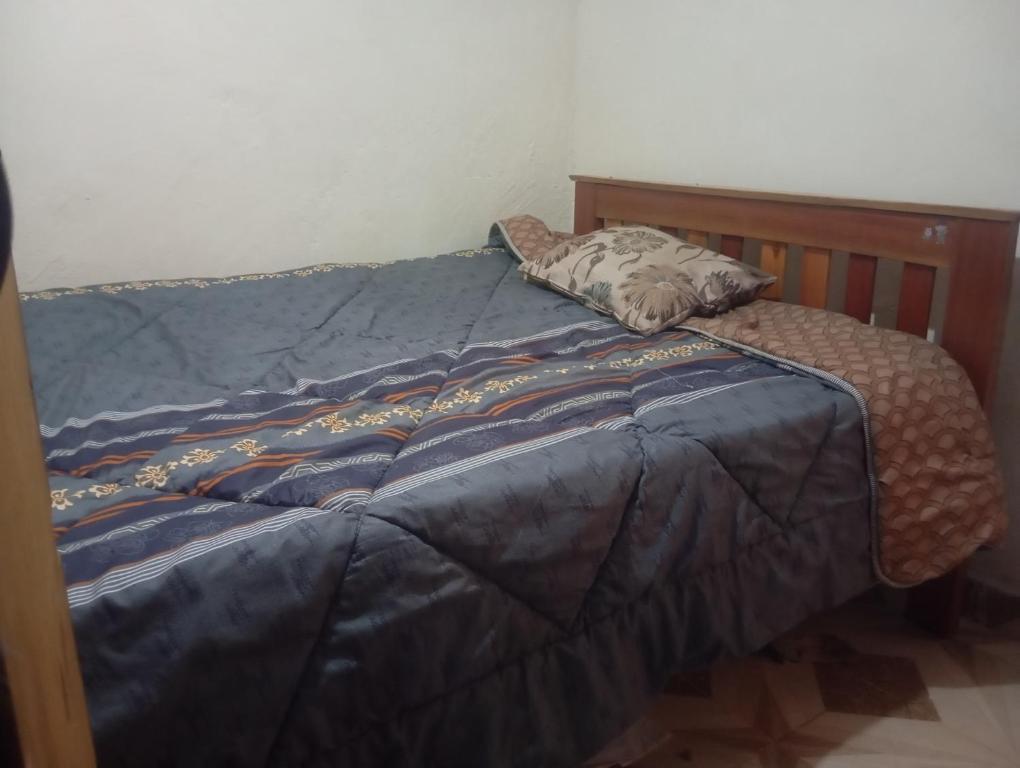 Una cama con un edredón azul y una almohada. en Valley View, en Kiambu