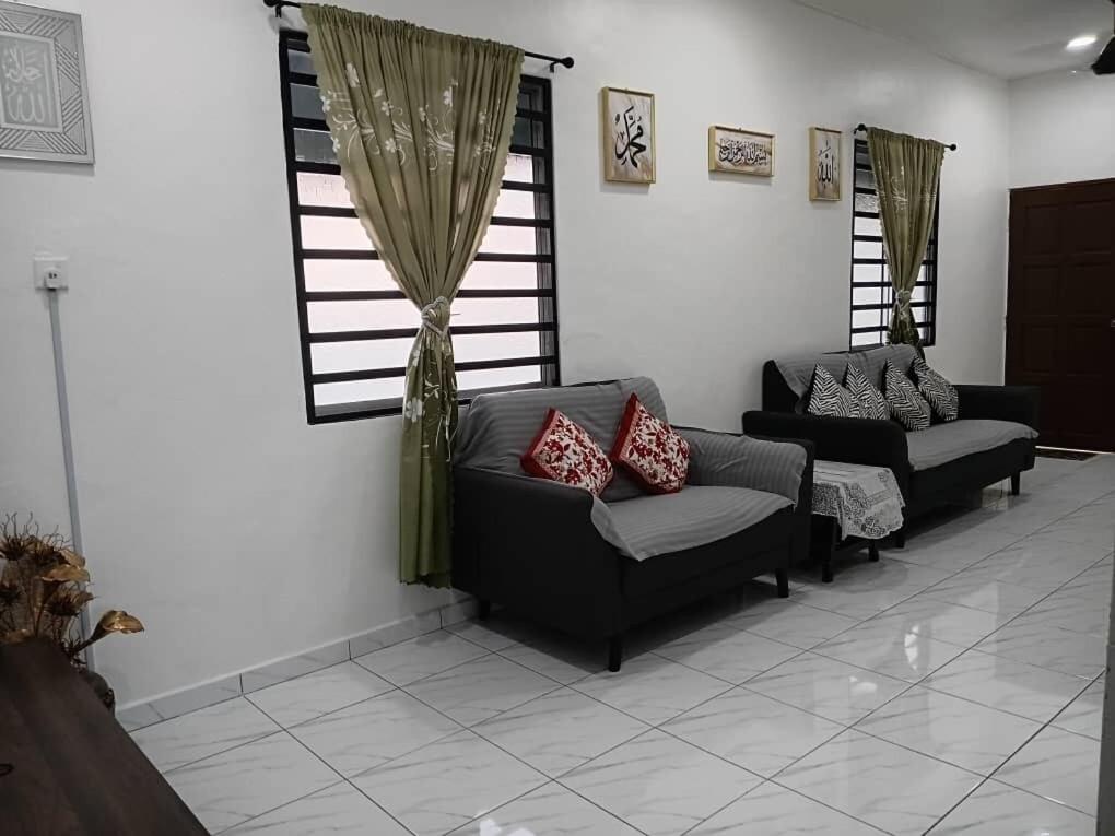 a living room with two couches and a window at Balqis LN Homestay in Taiping