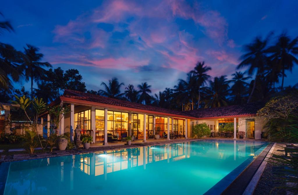 a villa with a swimming pool at night at Villa Blue Lotus Katunayake in Katunayake