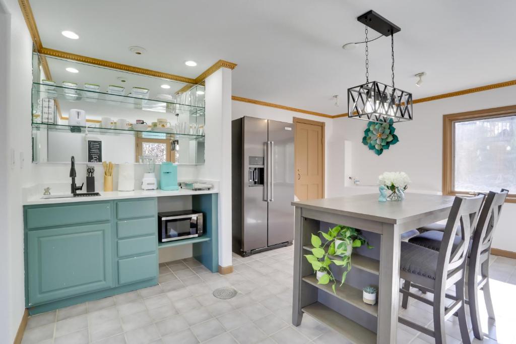 a kitchen with blue cabinets and a table with chairs at 6 Mi to Barr Lake Apt with Hot Tub Access! in Brighton