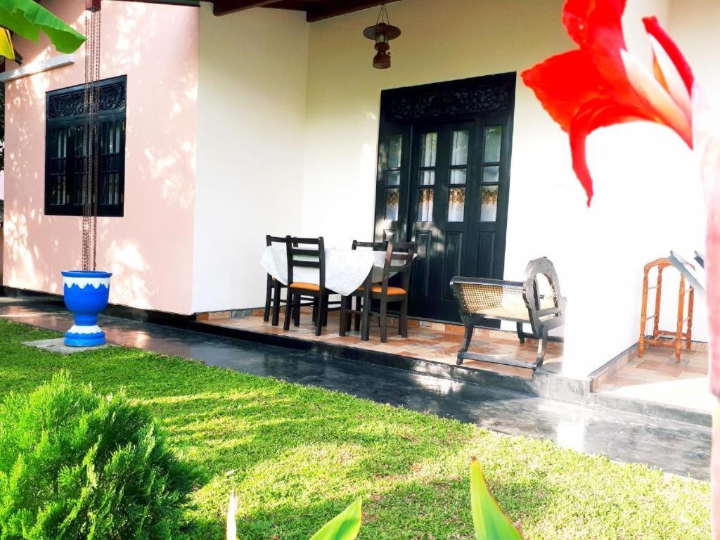 a front porch of a house with a table and chairs at Hansa Villa in Hikkaduwa