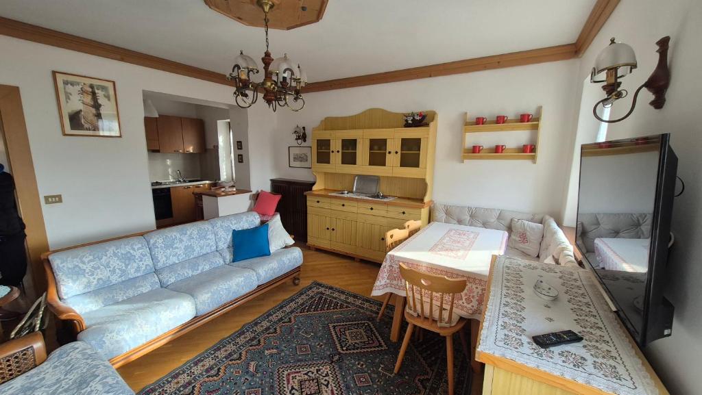 un salon avec un canapé et une table dans l'établissement Ca' Piloni appartamento con 3 camere, à Pieve di Cadore