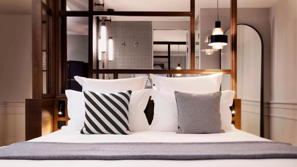 a bedroom with a white bed with pillows at Maison ELLE Paris in Paris