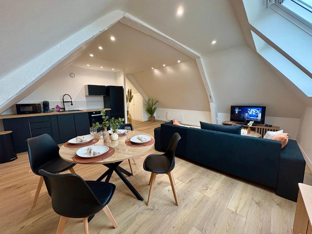 Una sala de estar con un sofá azul y una mesa. en Le Cocon Arras Centre & Netflix 4 pers, en Arras