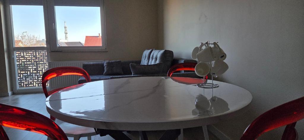 a dining room with a table and red chairs at Apartament Srebrny Quick Park Oława in Oława