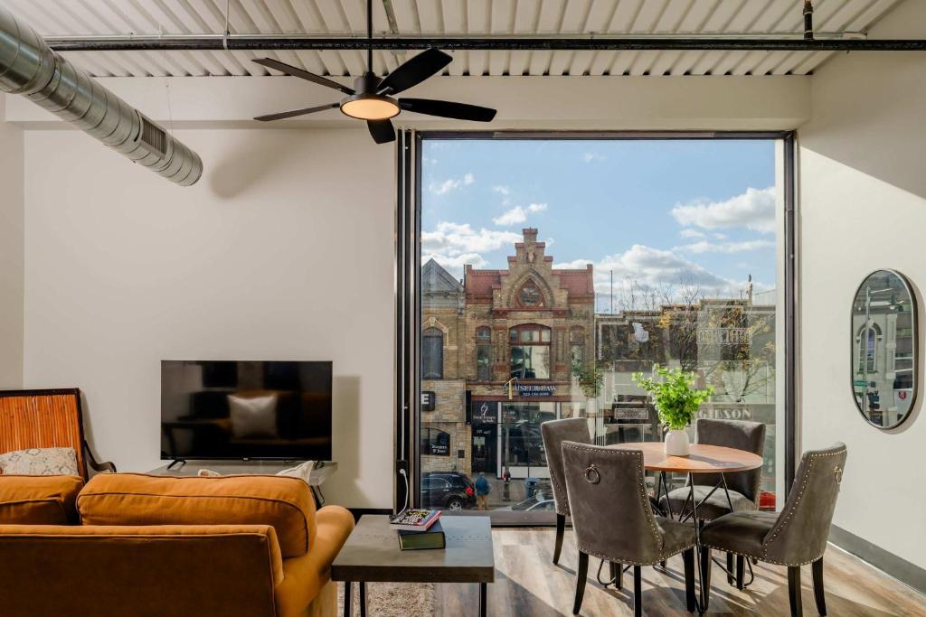 a living room with a couch and a large window at Modern City View 1BR Apartment with Office - free parking in Appleton