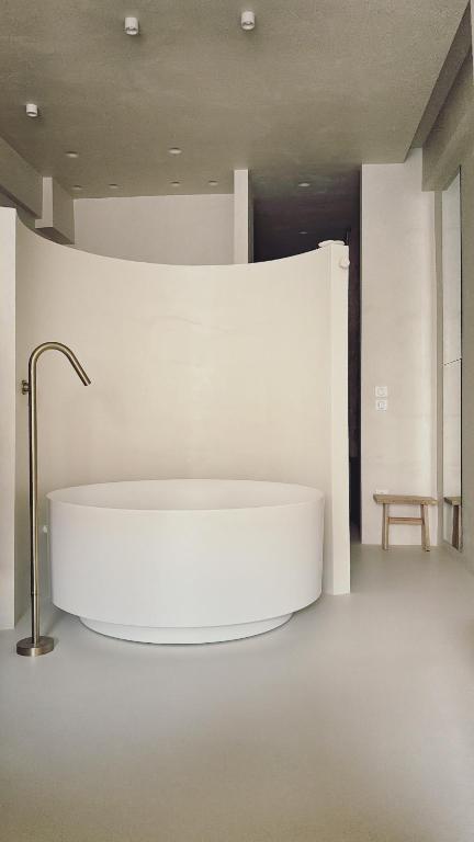 a large white bath tub in a room at âme casa in Mesochórion