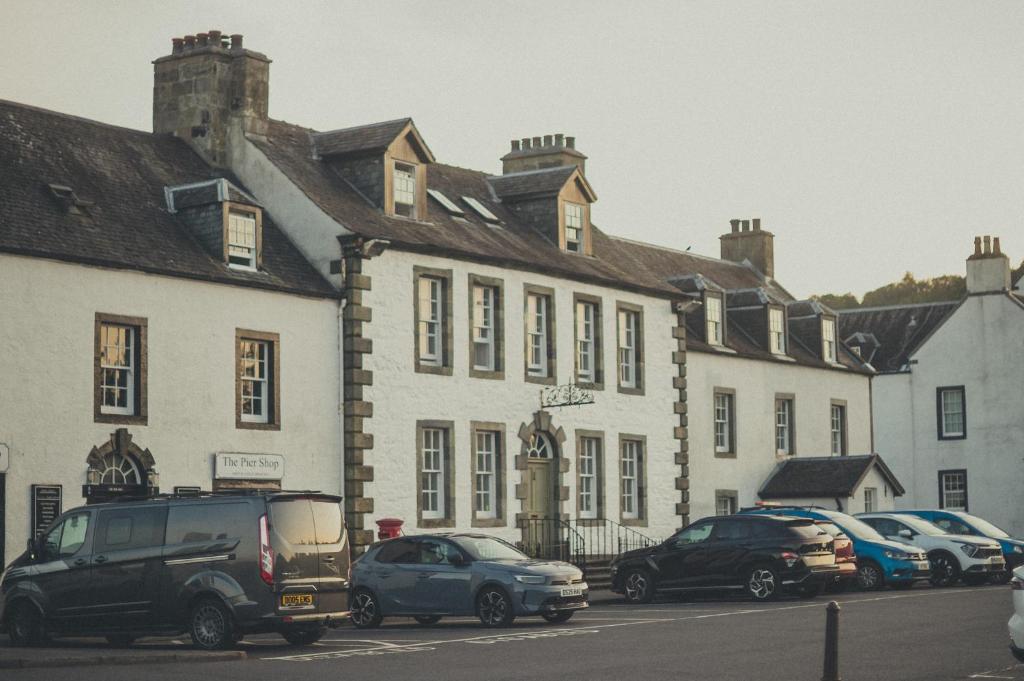 een groep auto's geparkeerd voor een gebouw bij NICHT' Apartments Inveraray Town Centre in Inveraray