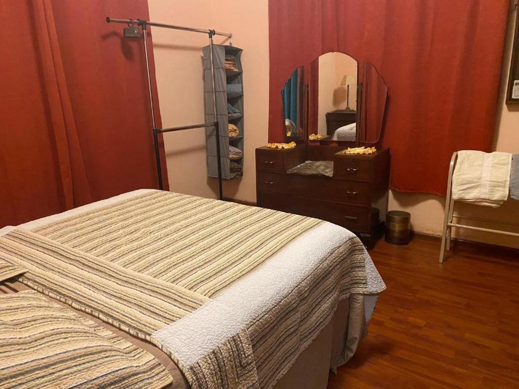 a bedroom with a bed and a dresser and a mirror at charming 1 bedroom house in Port-of-Spain