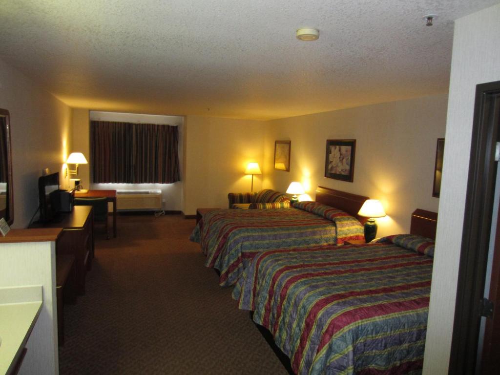Hospitality Inn tesisinde bir odada yatak veya yataklar