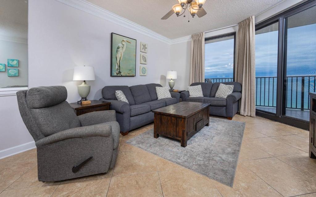 Phoenix X 1412 condo في شاطئ أورانج: غرفة معيشة مع كنب وكراسي وشرفة