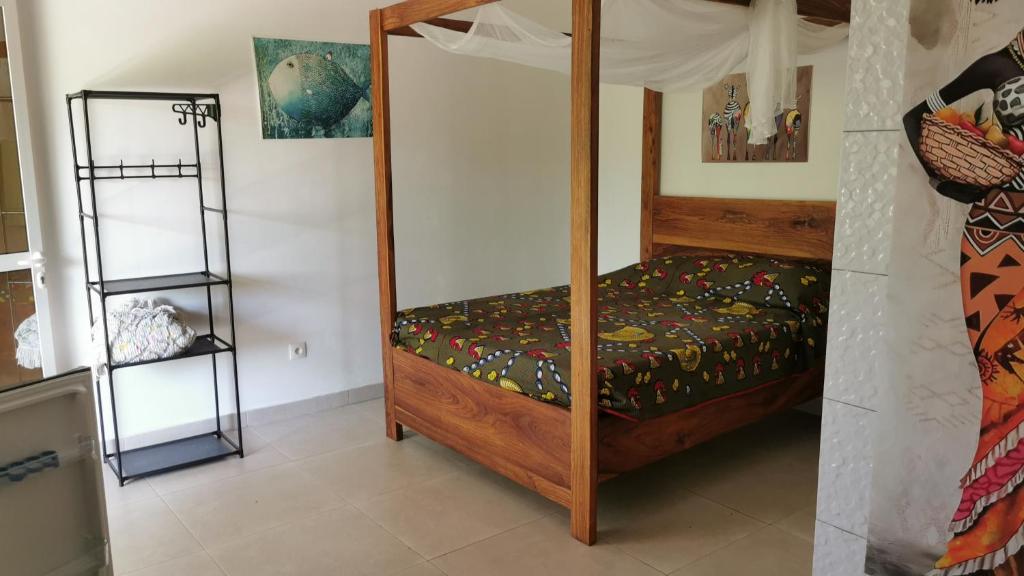 a bedroom with a wooden bunk bed in a room at Chambre a cap skirring avec acces piscine in Cap Skirring