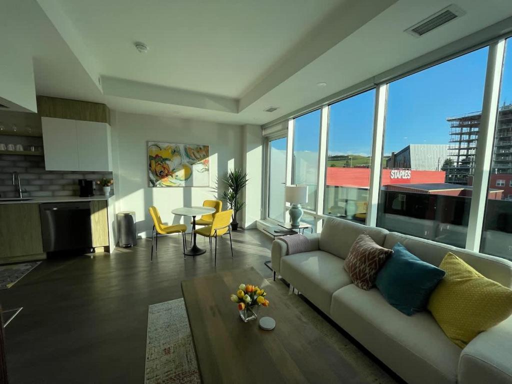 a living room with a couch and a table at Spotless & Bright 1 BR downtown with private patio in Halifax