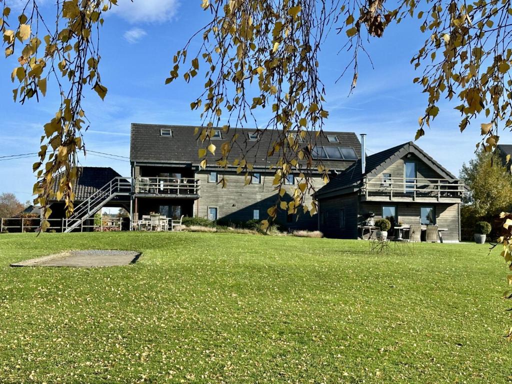 a house with a large yard in front of it at Petit Wilogne in Dinez