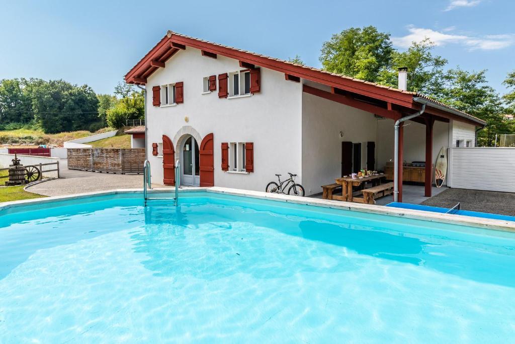 a villa with a swimming pool in front of a house at Harria in Bidache