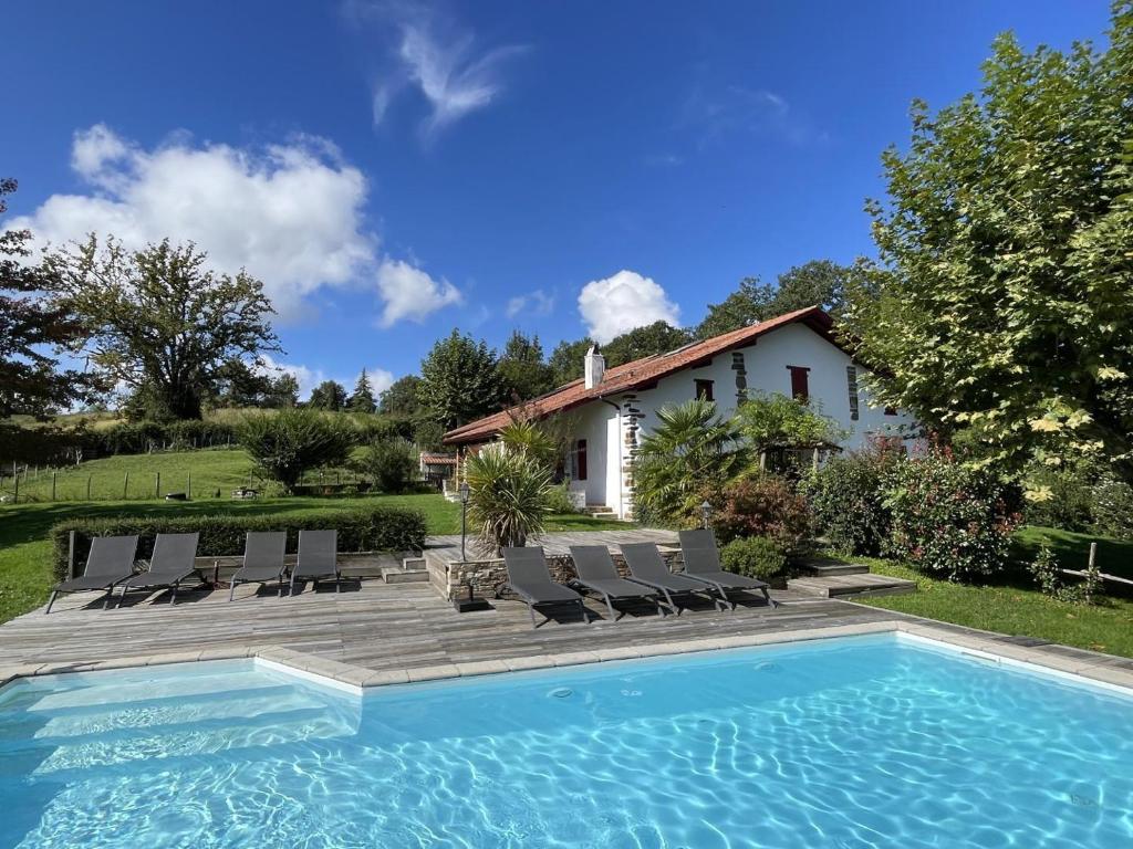 een villa met een zwembad en een huis bij Le clos gaxen in Labastide-Clairence