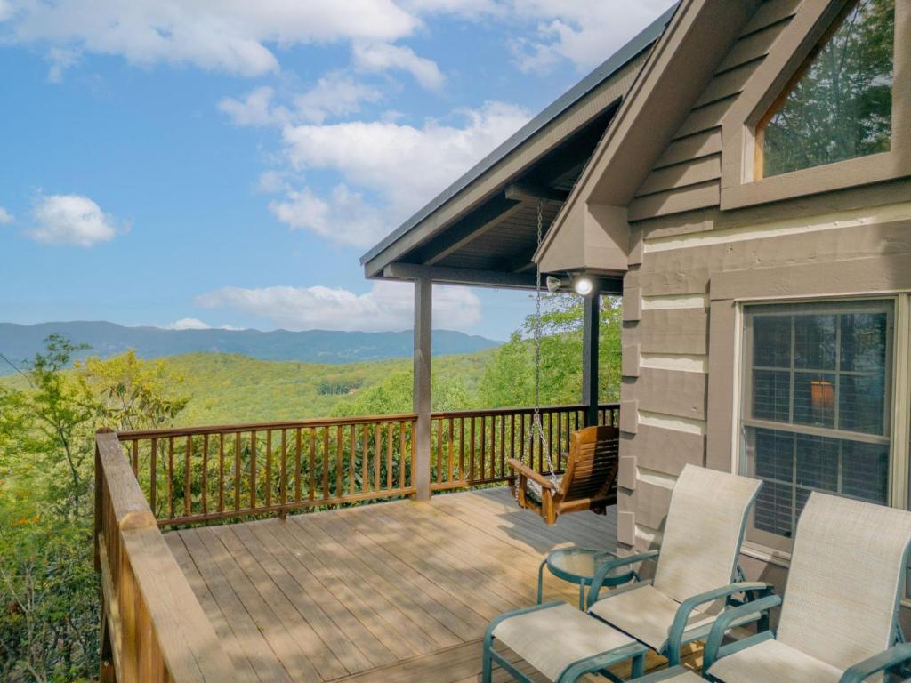 a deck with chairs and a view of the mountains at Mountain Masterpeace in Banner Elk