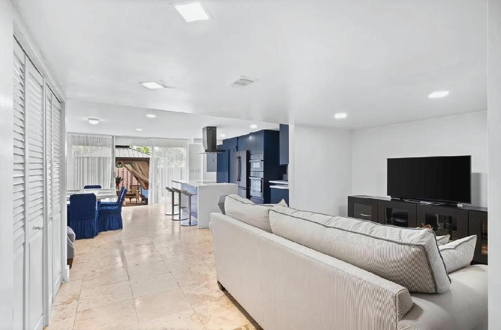 a living room with a couch and a tv at Bright Three-Bedroom Modern Apartment with Private Balcony in Hollywood Beach