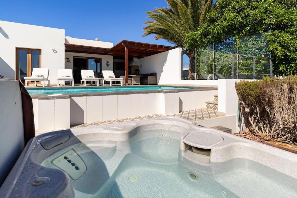 una piscina con jacuzzi frente a una casa en 3 bedroom villa with pool and jacuzzi, en Playa Blanca