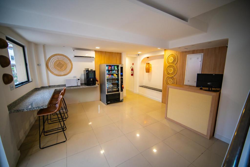 a kitchen with a counter and a bar with a refrigerator at Amazinn Hotel in Belém