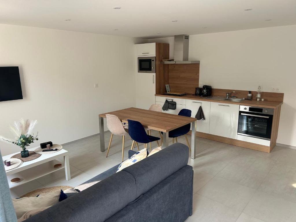 a living room with a couch and a table with chairs at Bleu horizon in Rosnoën