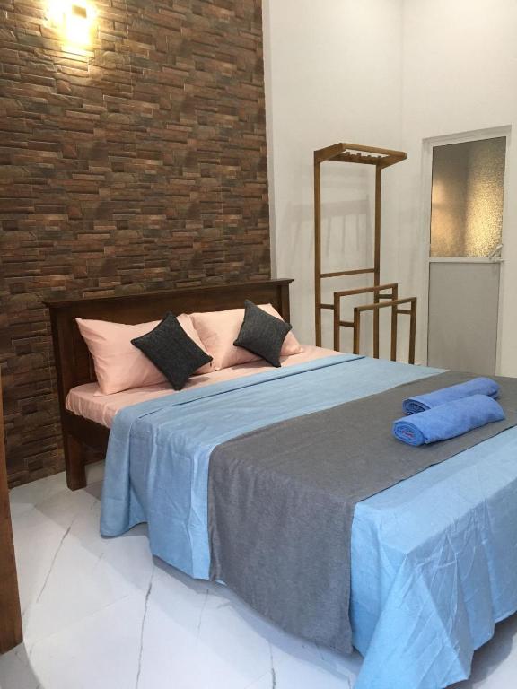 a bedroom with two beds and a brick wall at Moonlit resort in Minuwangoda