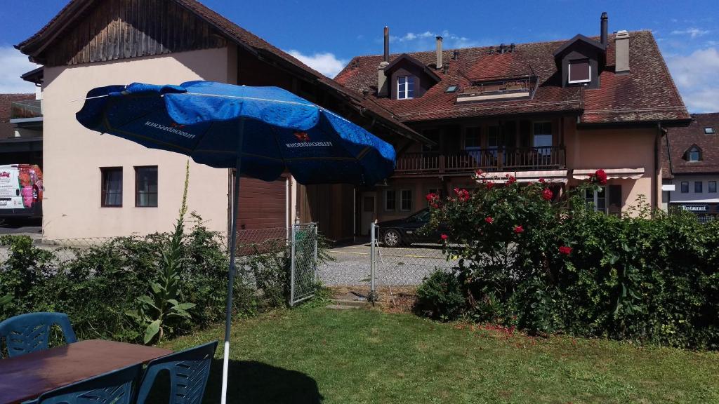 a blue umbrella in the yard of a house at Au P'tit Bonheur in Cheseaux