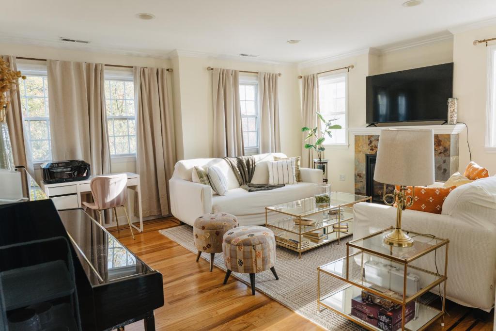 a living room with a white couch and a table at Urban Downtown Stamford Home 45 min to NYC with Garage And Yard in Stamford