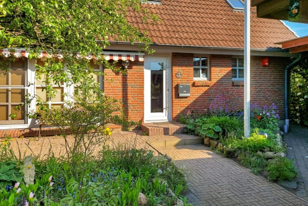 een bakstenen huis met een tuin ervoor bij Elkjer 24 in Großenwiehe