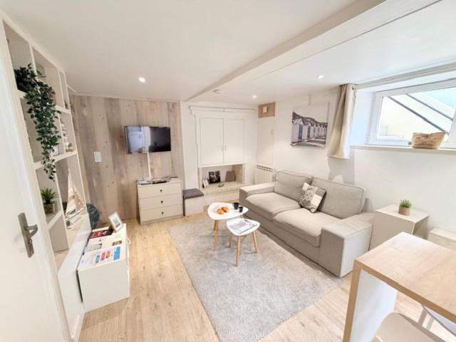 a living room with a couch and a table at Idéal couple ! Le Nid du Bourg - Proche plage et commerces - serviettes de toilette & linge de lit compris in Ouistreham